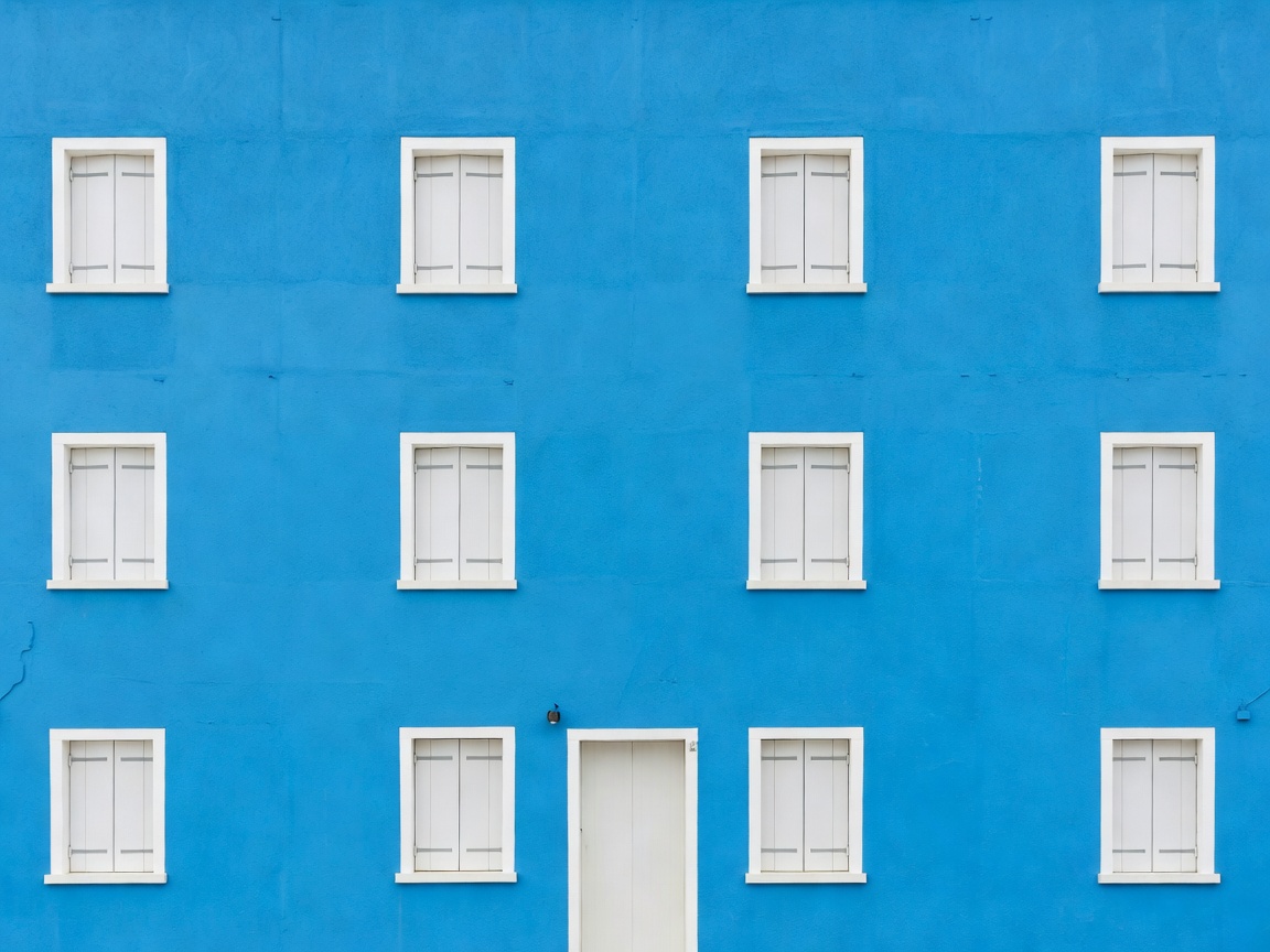A flat frontal view of a single bright Burano facade with no people or objects